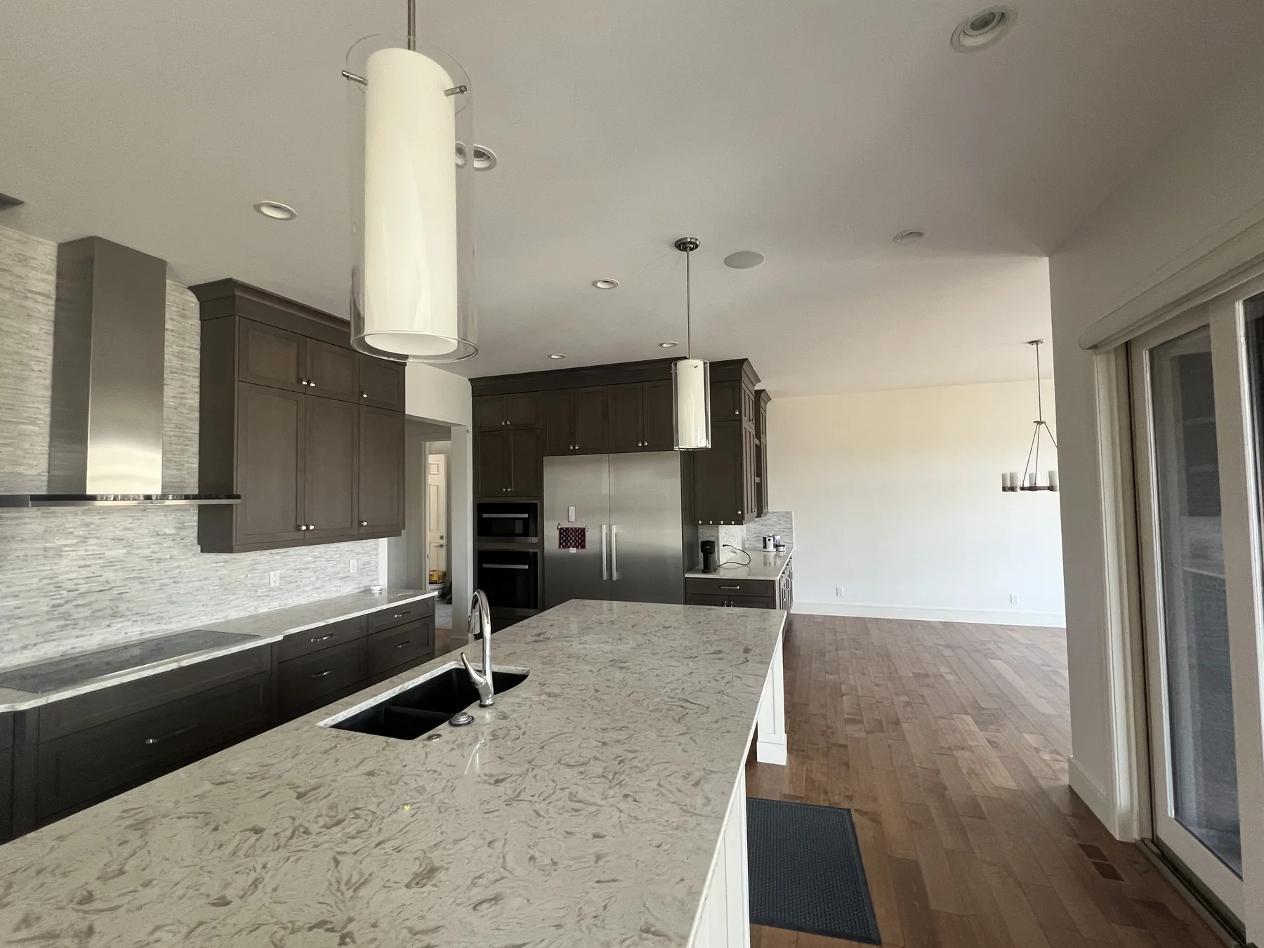 Finished kitchen in the same Calgary home with dark cabinetry light counters and freshly painted walls