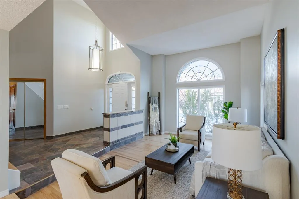 Vaulted Calgary living room from the same finished interior project with clean neutral walls and white trim